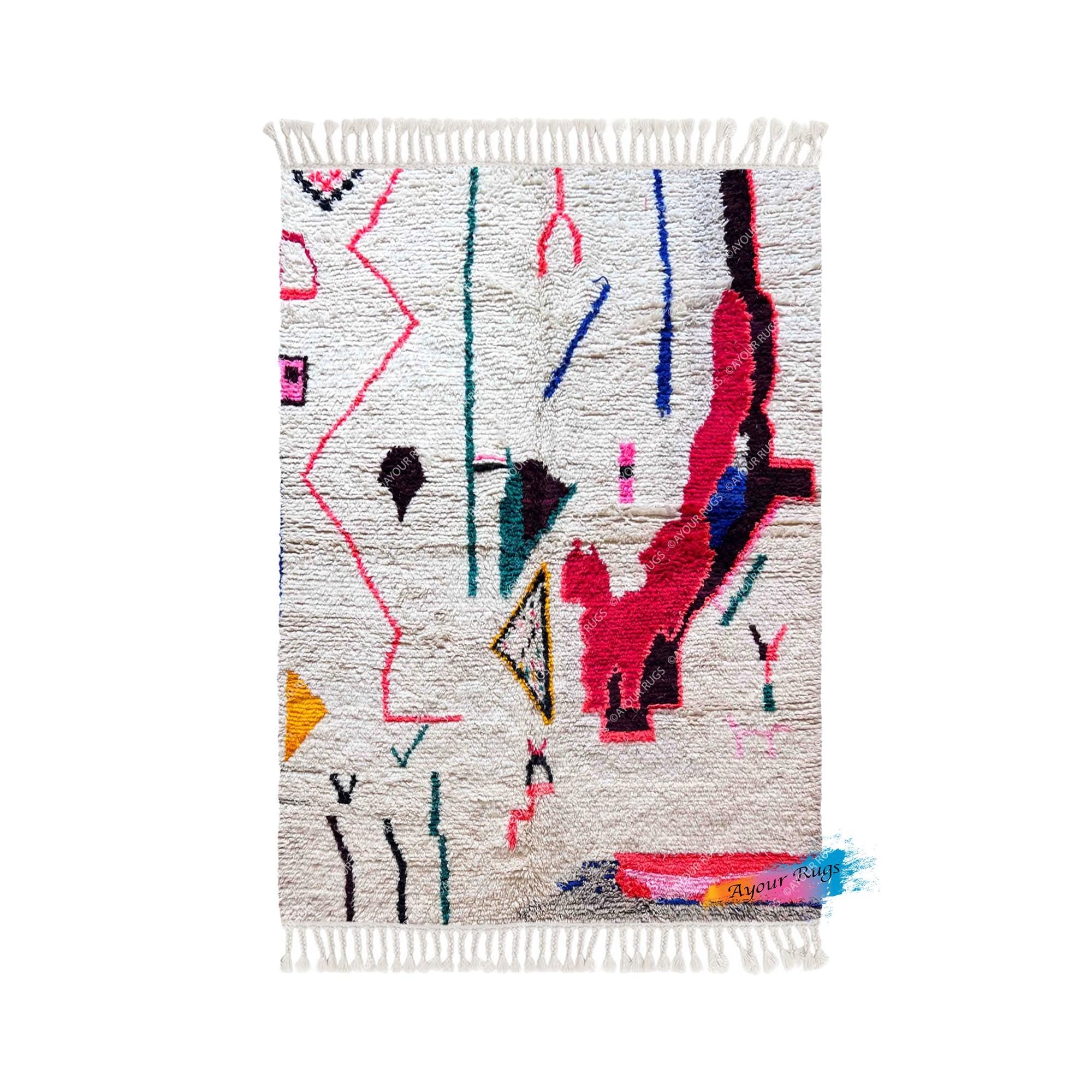 a vibrant, abstract rug with a variety of geometric shapes and patterns in a range of bright colors, including pink, blue, green, and yellow.